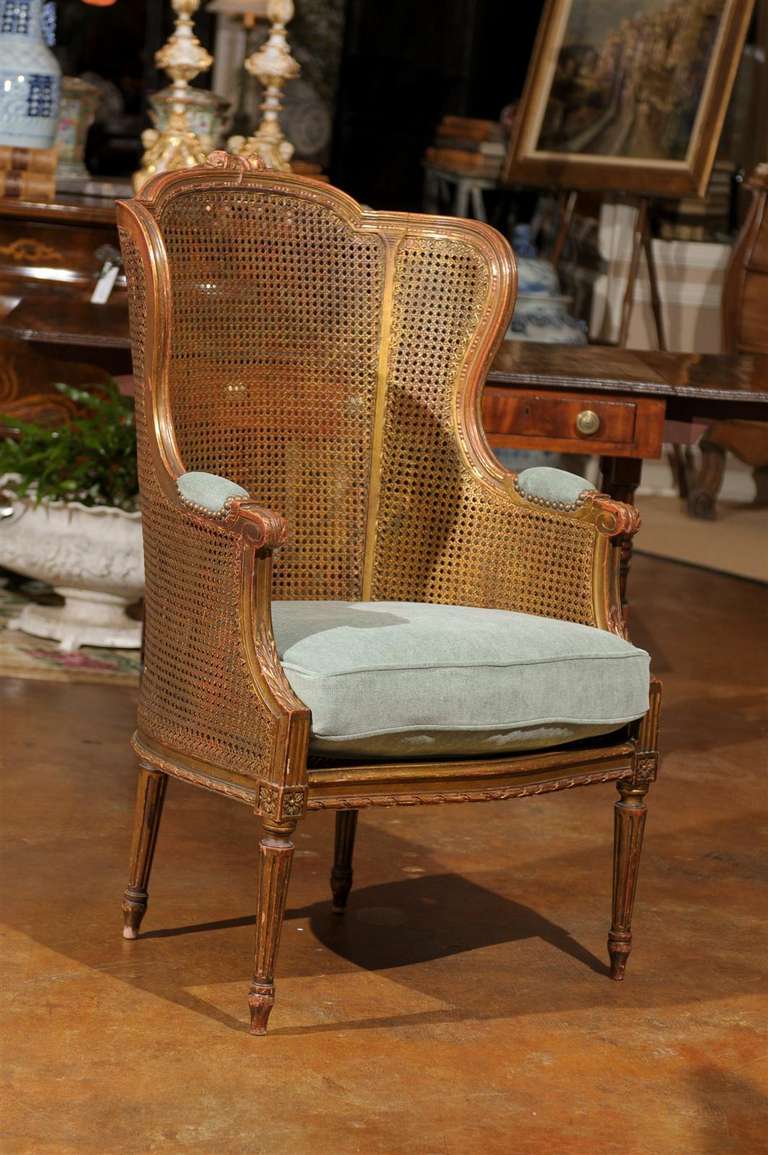 This is a gorgeous French Louis XVI caned chair in wonderful condition. The seat is caned with a newly constructed green linen velvet fabric. Gold leaf with gesso showing through. Beautiful carving.