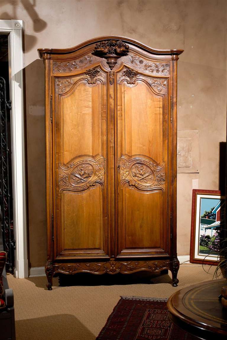 Mid 19th century walnut armoire has been beautifully hand carved on the outside and nicely finished on the inside.