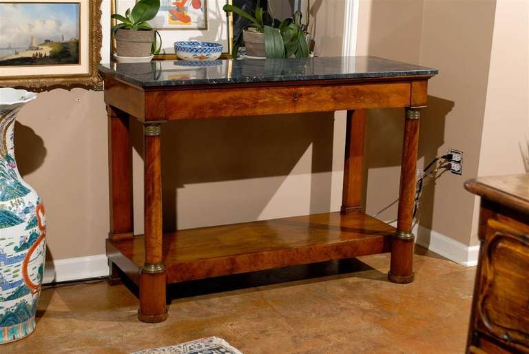 Period Walnut Empire console. With all original bronze mounts. Long center drawer with a marble top that is black and gray with gold slightly running through it. Walnut is book marked on bottom shelf.