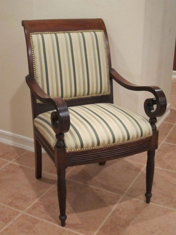 An American Federal Lolling Chair with exquisite lines.  The bold square back has a slight turning at the crest rail, while the arms sweep gracefully to the front of the chair, with a bold scroll that terminates into the front legs.  The seat rail