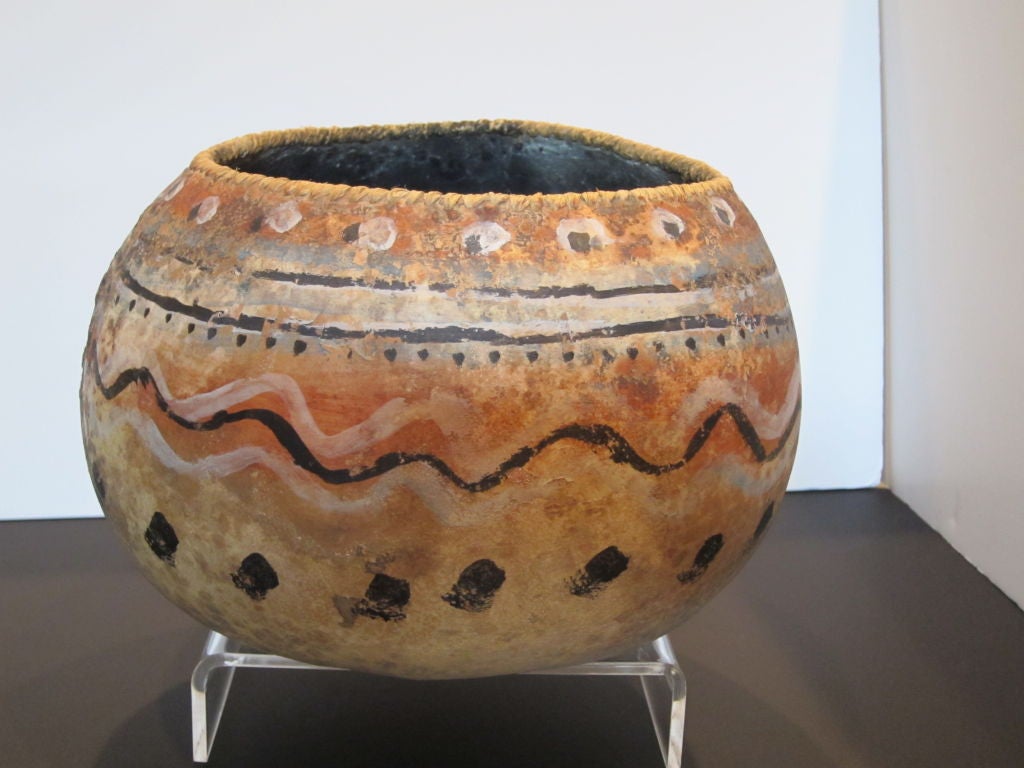 This is a very early painted gourd by famed New Mexico artist Robert Rivera.  The gourd is hollowed out and painted with Navajo and Hopi Native American Indian designs.  The primary colors are black and a pale grey with a hint of lavender. This