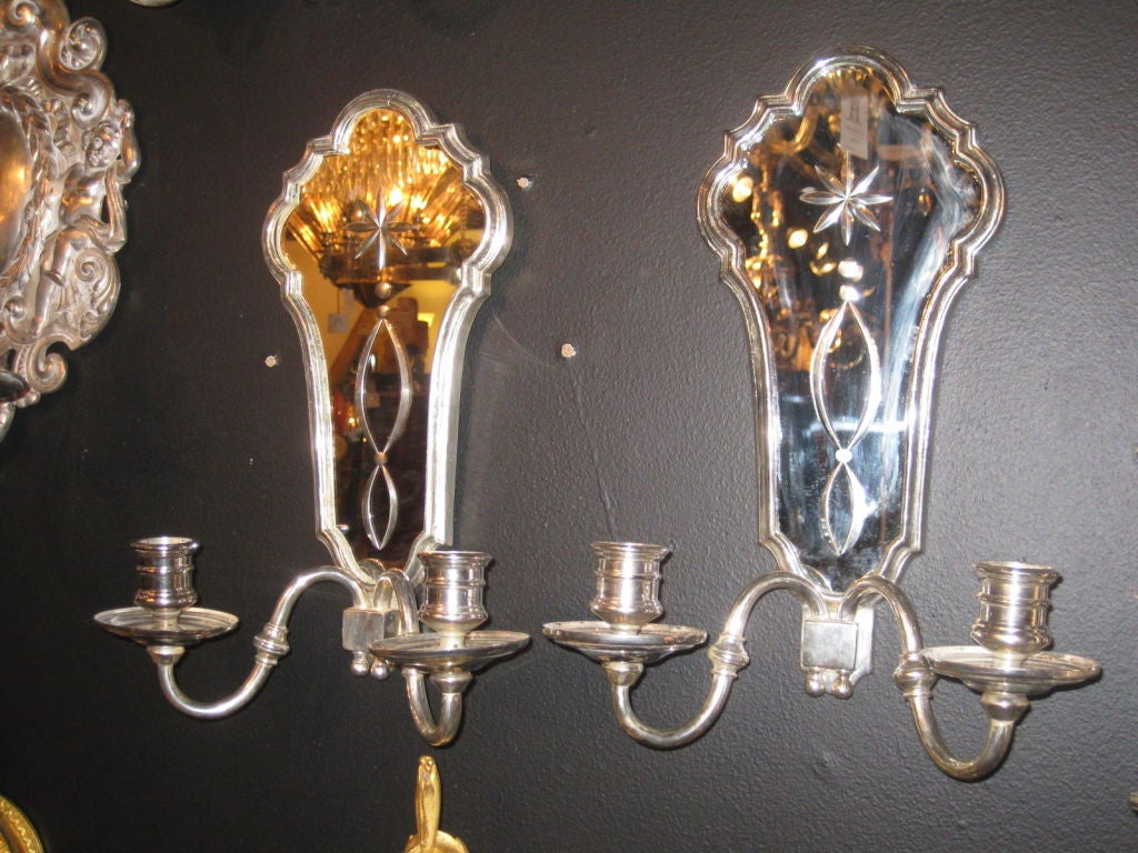 Set of 8 silver plated mirror back sconces. Priced per pair. There are also a set of 6 available in gilt bronze.