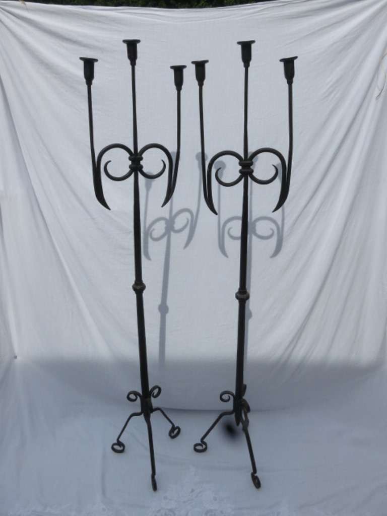 Unique pair of wrought iron candlelabrum with splayed feet.