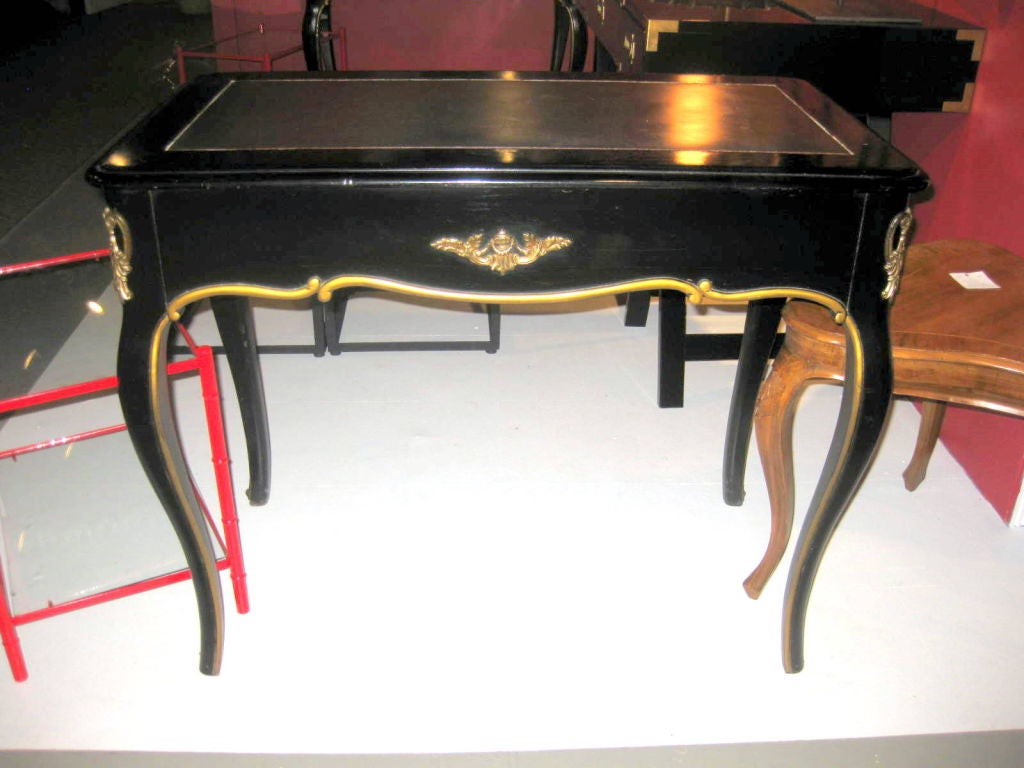 Ebonized and gilded small desk with a leather top
