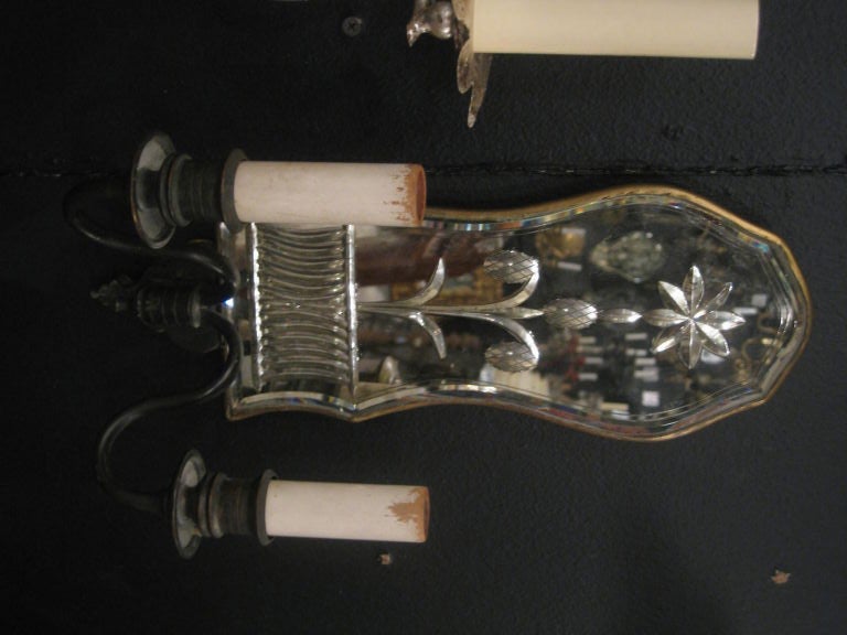 A pair of Caldwell sconces with a mirrored backplate. Original finish and patina