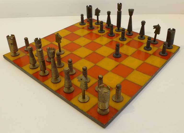 Modernist chess set with lathe-turned metal pieces and a board of translucent plastic adhered to wood, trimmed in brass.  A machine-age design hand made in Germany c. 1930's.  Complete and in fine condition, with only age-appropriate wear to the