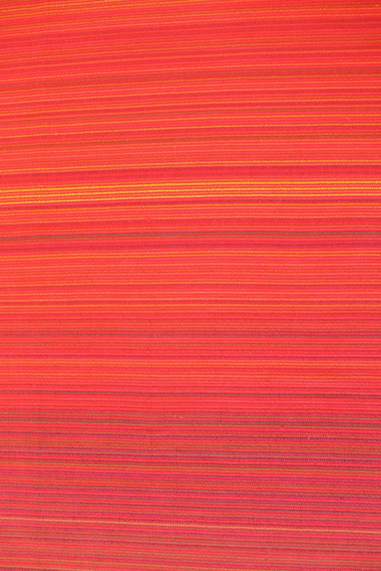 Wall-hanging, flat-weave textile by FInnish textile artist Ritva Puotila (b. 1935), done in the early 1960's for Ted and Martha Nierenberg, founders of Dansk.  The pattern is a subtly modulated color field of red and orange lines, with dashes of