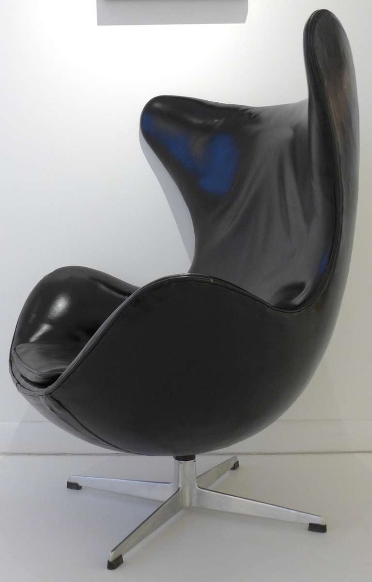 Vintage Arne Jacobsen 'Egg' Chair in original black leather, with early flanged cast aluminum base.  Produced by Fritz Hansen, c. 1960's.  The leather has been cleaned, polished, and shined, and is in good original condition except for a 12