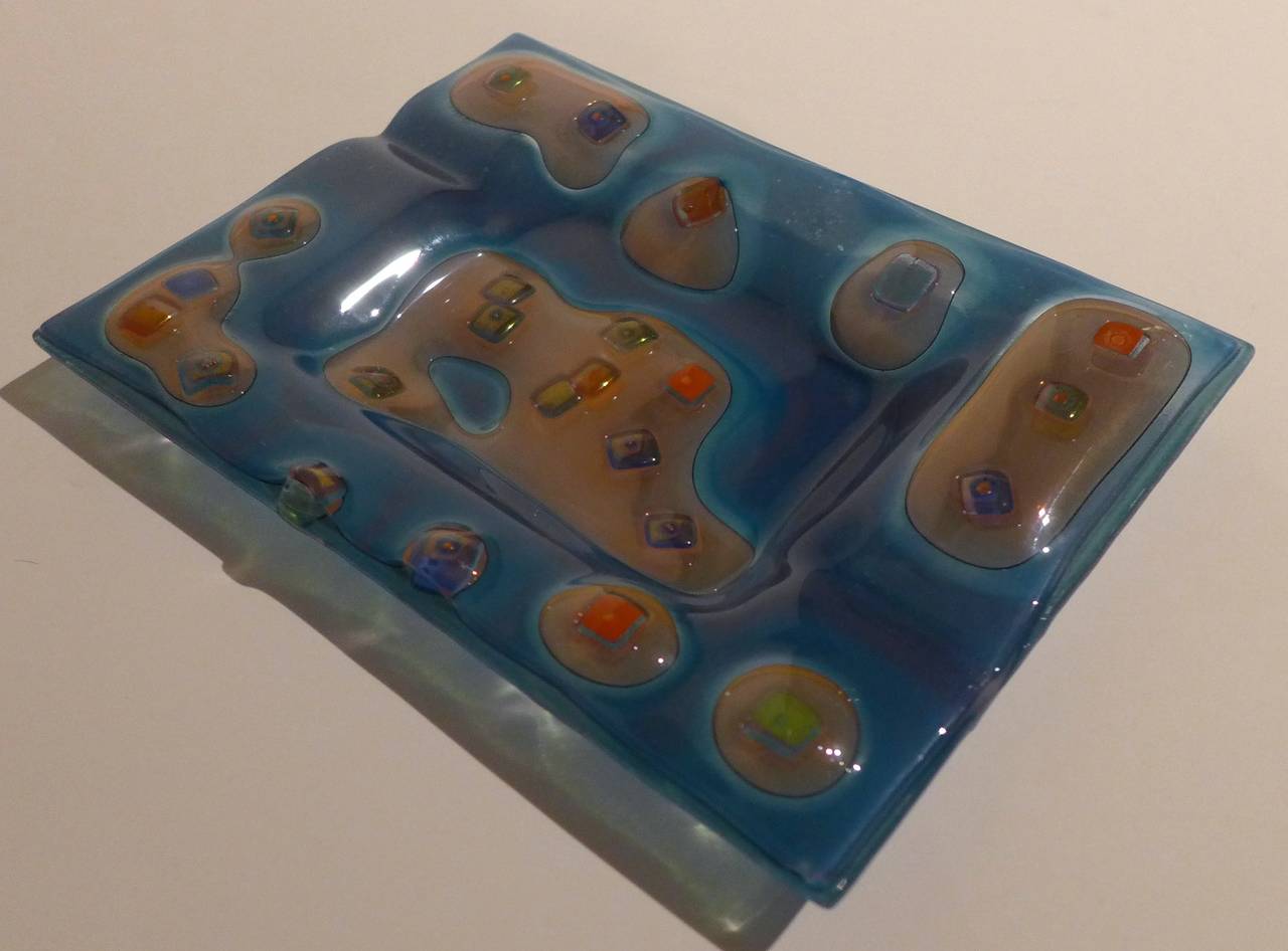 Dish or ashtray of fused glass by Michael Higgins, executed c. 1950's.  An early work, done by hand, with a good abstract pattern, bearing the incised signature and the initial 