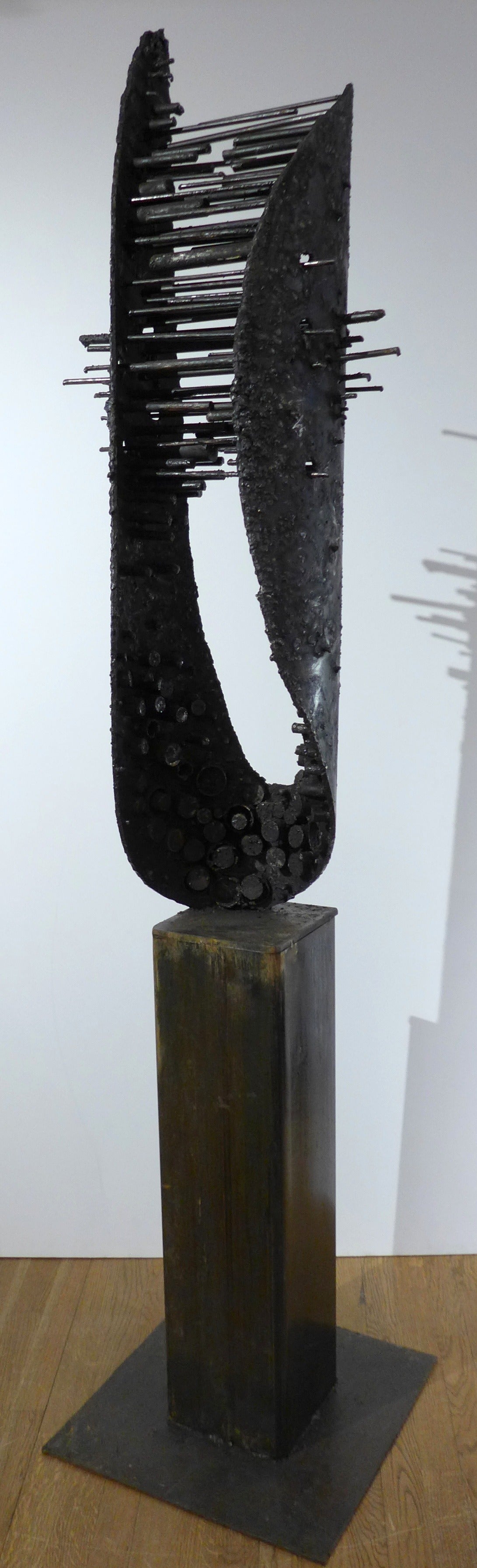 Abstract sculpture of welded, blackened and textured steel by Des Moines artist James Anthony Bearden. Titled 