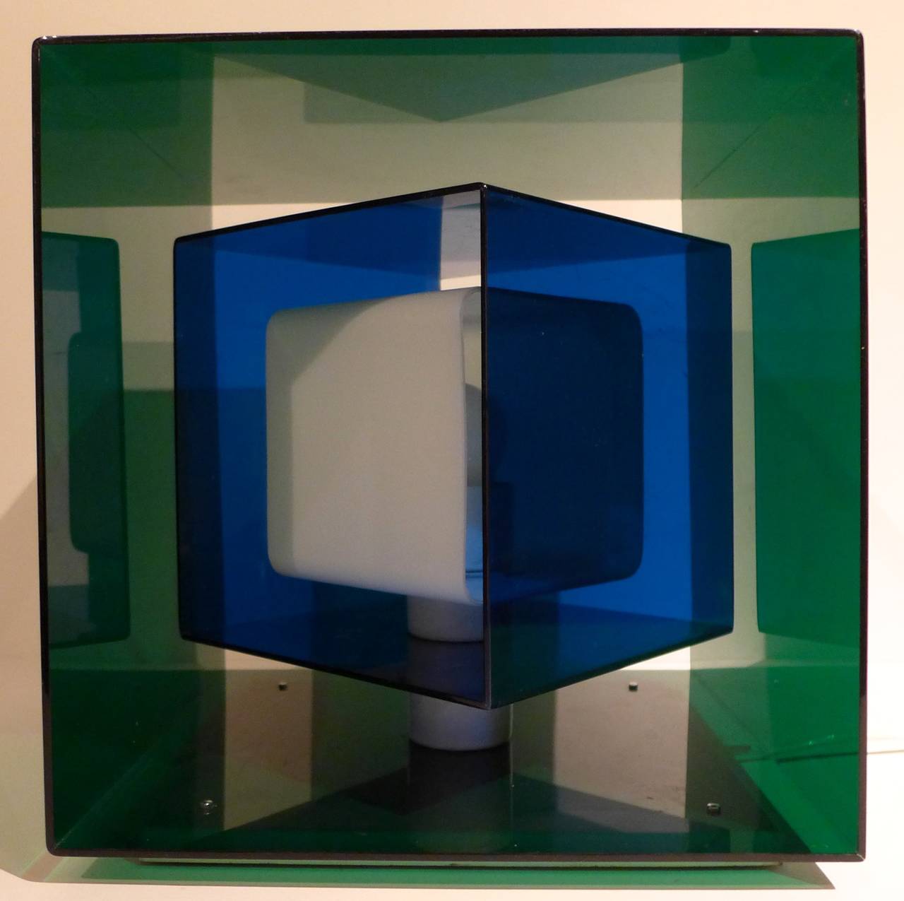 Table lamp consisting of three concentric cubes, the outer two of acrylic and the inner one of opaline glass, on a metal base plate. Made in small numbers by Stilnovo, Italy, circa 1970. The inner two cubes can rotate to provide different visual