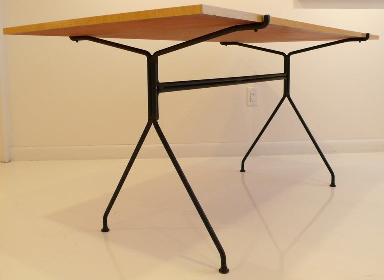 Dining or writing table designed by NYC-based industrial designer and educator Norman Cherner.  Part of the Konwiser Collection, produced c. 1953.  Wrought iron base with a faux-grained formica veneered top.  In fine original condition, with just a