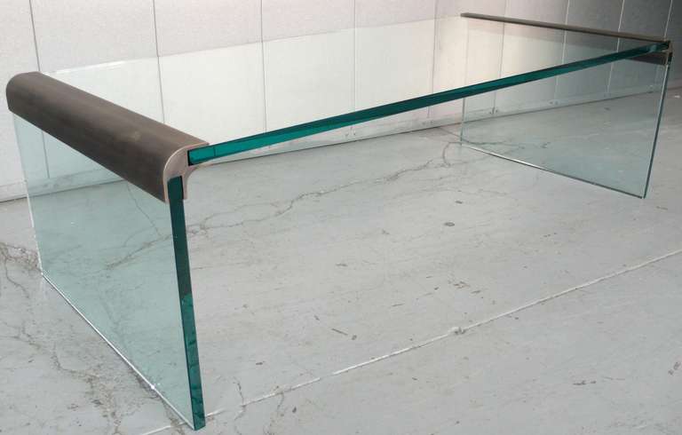 Cocktail table of bronzed steel with original polished glass, from the Pace Collection, c. 1970's.  Small chip to bottom edge of one base, pictured.  Also, a 3