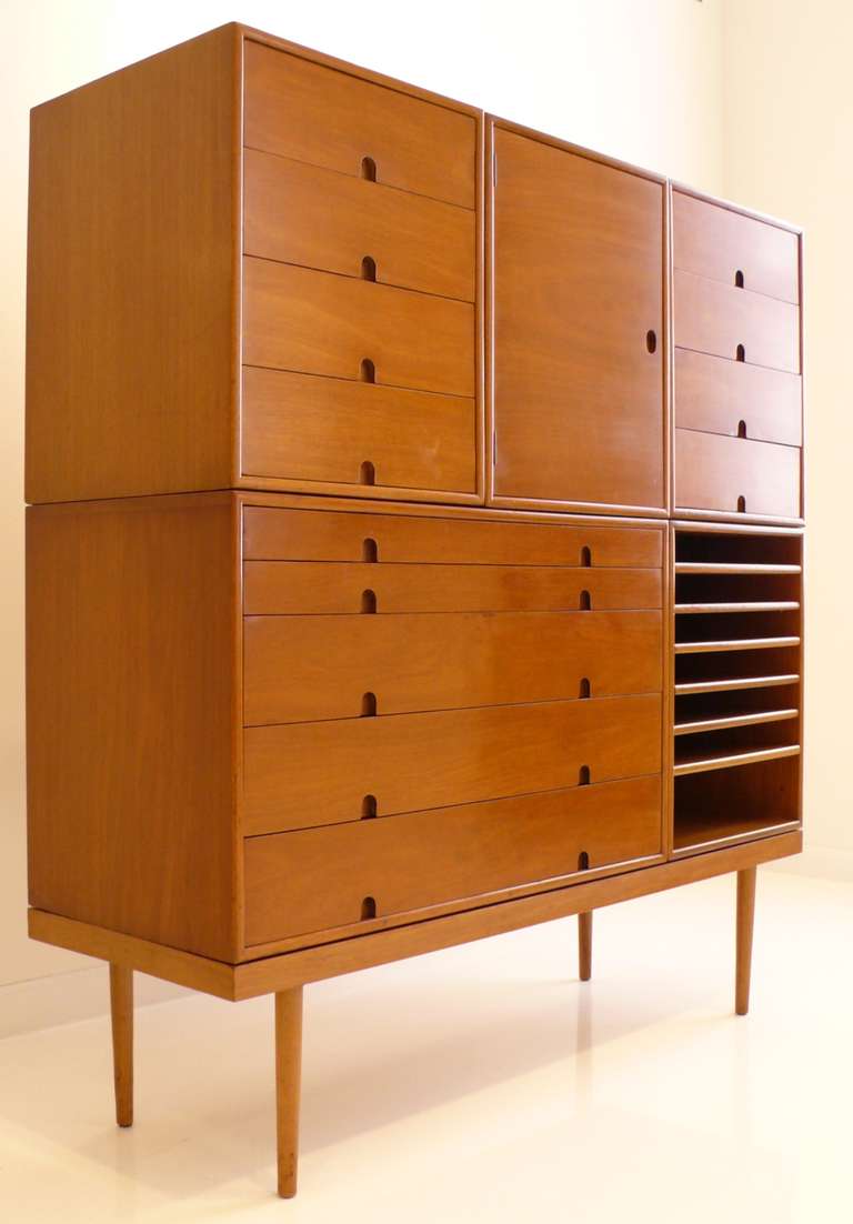 Unadorned but graphically powerful seven-piece grouping of modular case goods designed by Charles Eames and Eero Saarinen, comprising two four-drawer units, one unit with a door, an open unit with six shelves, a double-wide four drawer unit, and two