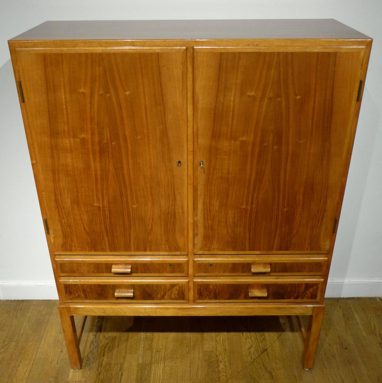 Service cabinet in figured mahogany with birch interiors and original brass hinges and escutcheons. The two doors each conceal two adjustable shelves, with four drawers underneath. A well-made and nicely proportioned piece by Danish master