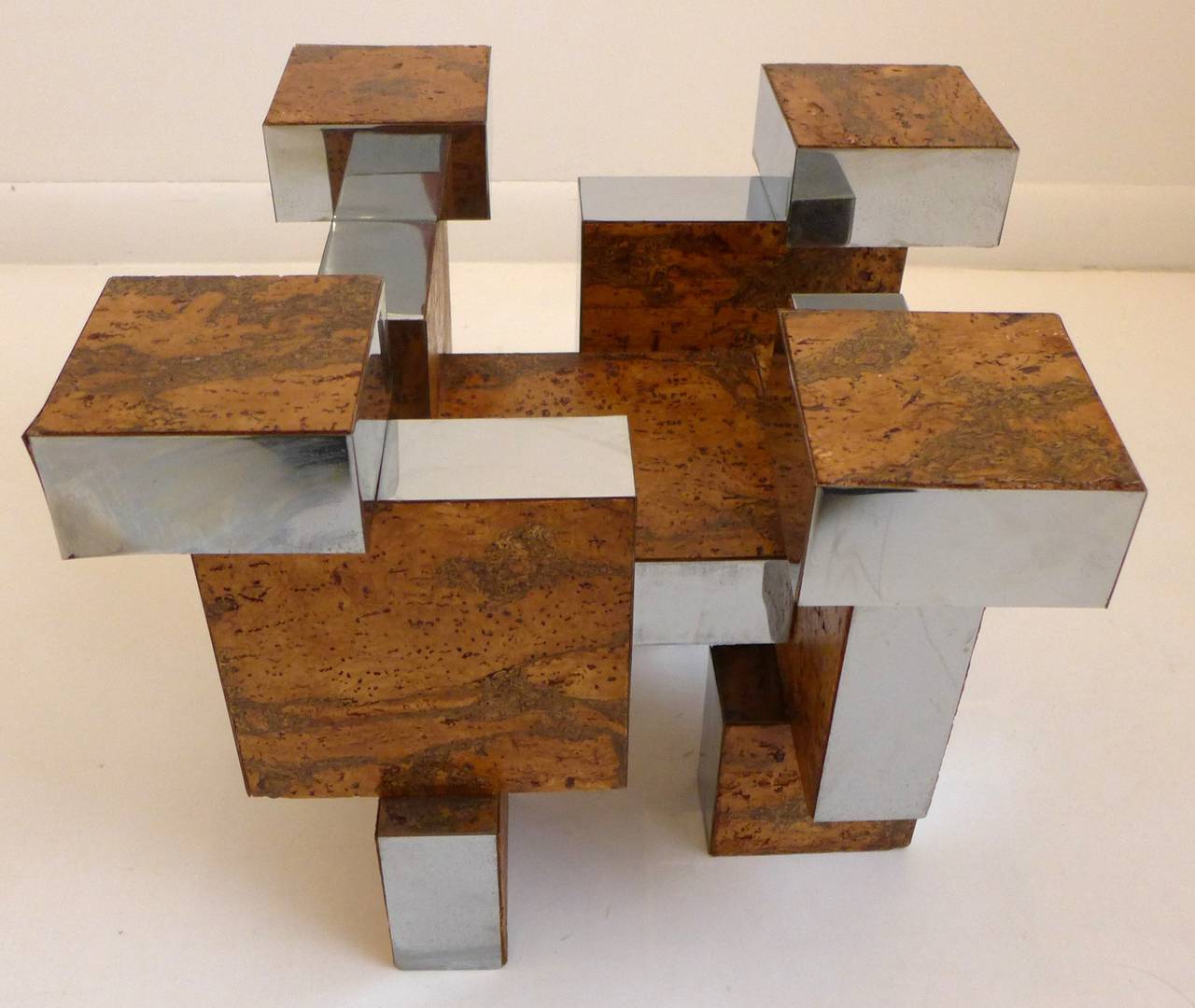 Brutalist cocktail or side table base, comprised of vertical and horizontal blocks of wood clad in chromed metal and olive burl cork veneer.  An architecturally sculptural form, executed c. 1960's, in the style of Paul Evans' Cityscape series. Sold