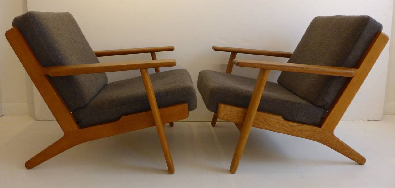 Pair of armchairs in solid oak, designed by Hans Wegner and made in Denmark by GETAMA, circa 1960s. Model no. GE-290. In fine vintage condition; the wood has been cleaned and polished, cushions have been reupholstered in the past several years.