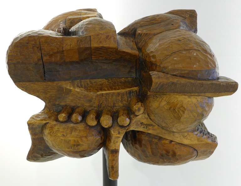 Abstract sculpture of carved, hewn and laminated oak, most likely of Latin American origin. On a vintage, though not necessarily original, metal stanchion. A hefty and quirky work, with a brutalist, and slightly aeronautic, aspect. Signed 