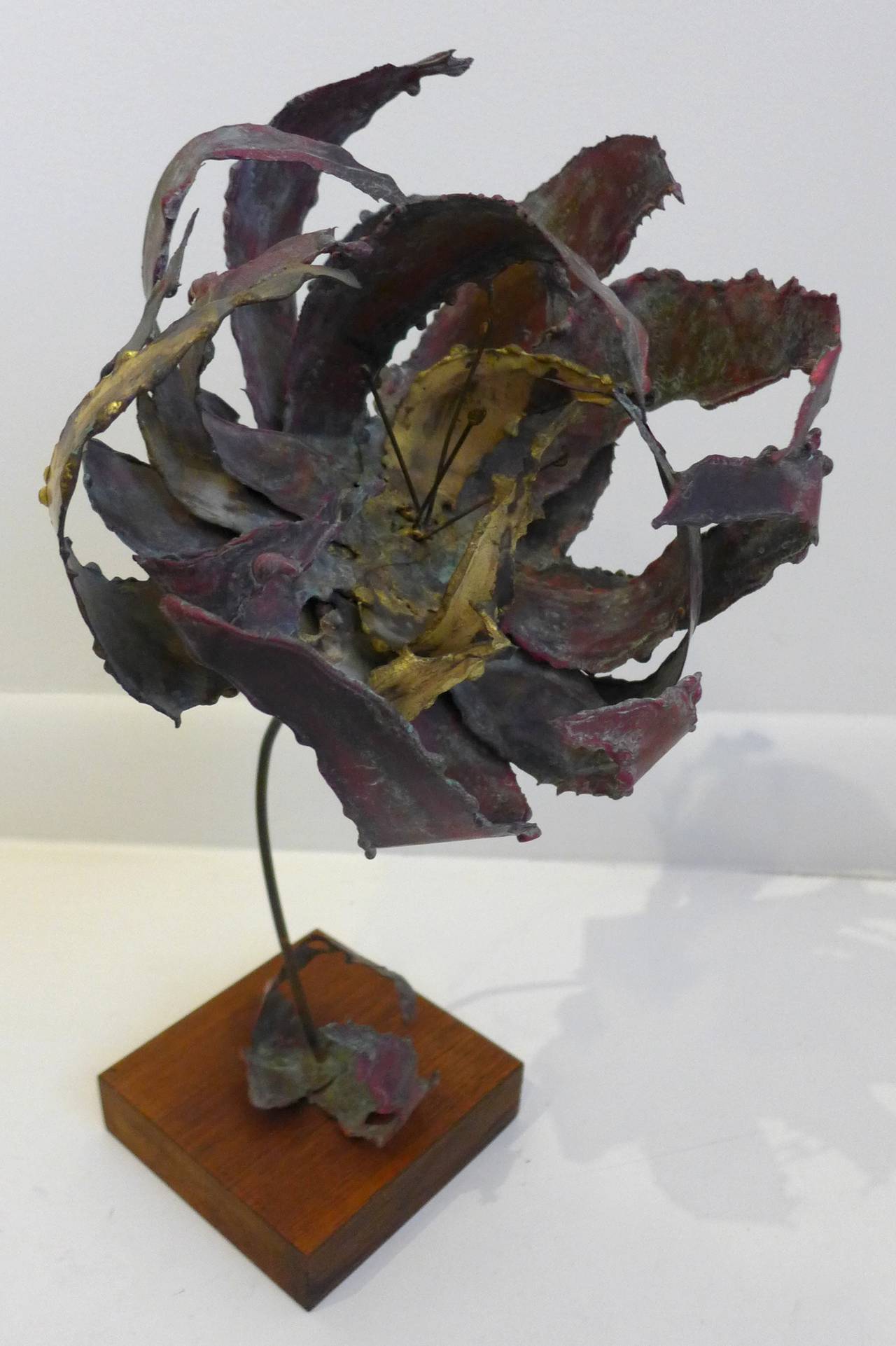 Brutalist floral sculpture of torch-cut, patinated, colored, and bent metal, on a wooden base.  By Silas Seandel, c. 1970's.  A nicely rendered and mounted example of one of Seandel's brutalist flower shapes he used in tables, lamps, and