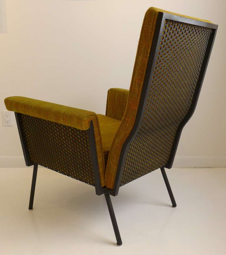 Rakishly curved armchair designed by NYC-based designer William Armbruster for his company Edgewood Furniture, produced c. 1950. The stylish lines and perforated metal backing captured editorial attention in the early 1950's, though this is the