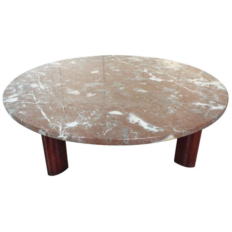 Midcentury cocktail table with beautifully figured and highly polished rose marble top on a base with flanged wooden legs.  The shape of the legs echoes the work of Osvaldo Borsani and Charlotte Perriand.  The table was likely made in Italy, circa
