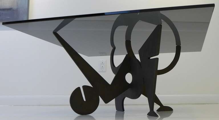 Sculptural cocktail table with an interlocking, two-piece bronze base and smoked glass top by Italian-born, Paris-based designer and artist Pucci de Rossi (1947-2013), produced c. 1980.  An early iteration of design/art, limning the