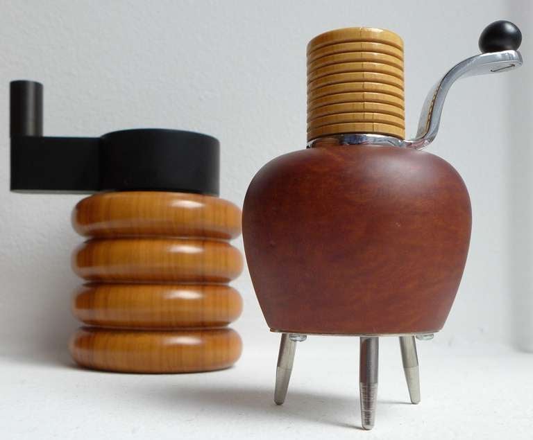 Two sculptural pepper mills produced by Alessi in the early 1990's as part of the Twergi collection, a series commissioned by Alberto Alessi and designed by associates of Ettore Sottsass.  The first, of cherry and aluminum, was designed by Adelberto