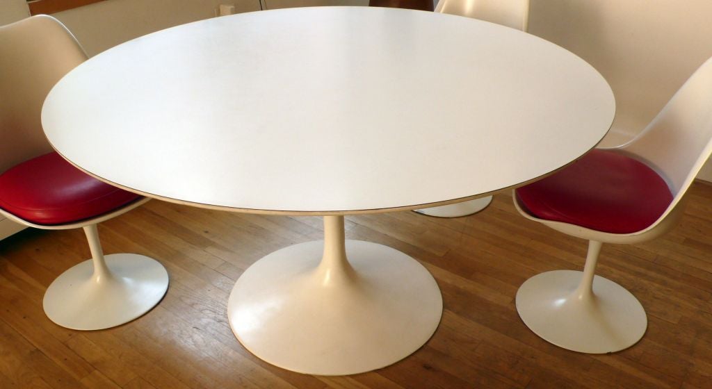 Tulip group table with white micarta top, along with four tulip group armless chairs<br />
with red vinyl pads.  Designed by Eero Saarinen in 1956, and produced by Knoll, c, 1970's.
