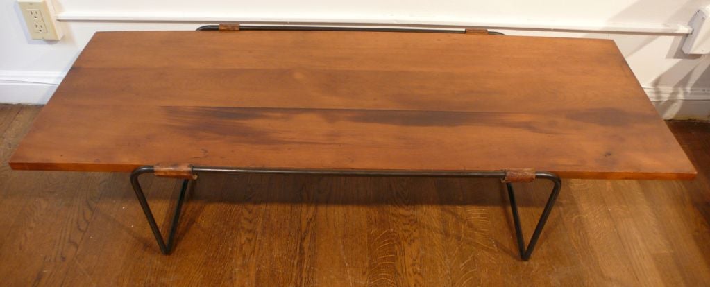 Coffee table with walnut top and rolled steel base with saddle leather supports.<br />
Designed and produced by the husband and wife team of Donald and Lila Swift Monell.  The base of the table 