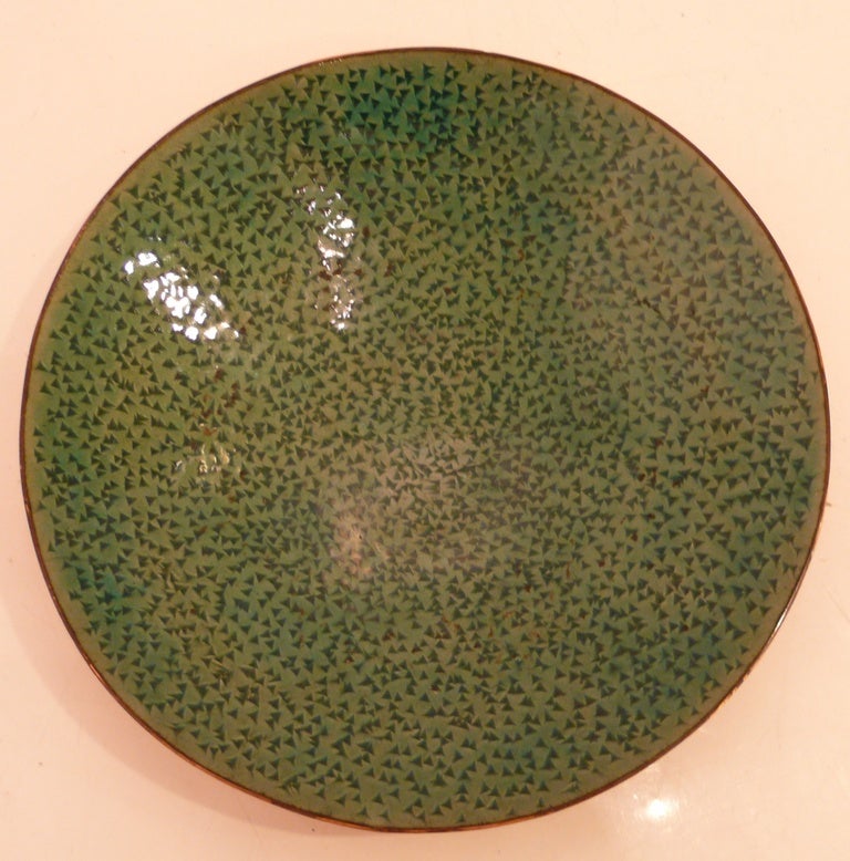 Shallow footed bowls of enamel on hammered copper by the Austrian firm Steinbock, c. 1950's.  One circular bowl with a patterned green enamel interior, and one eccentric shaped dish with a reddish brown enameled interior and blackened