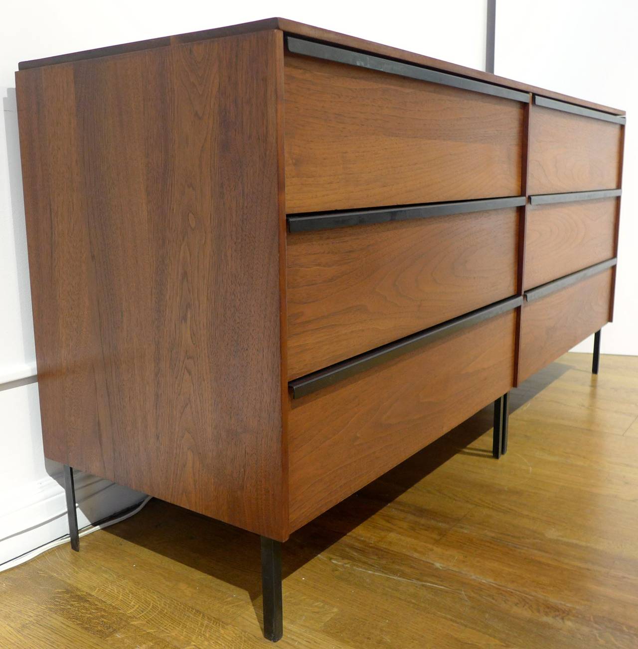 Double chest in walnut with linear steel pulls, steel angle framing, and white laminate drawer bottoms. Part of a modular series by New York City designer, teacher, and author Norman Cherner. The structural framing forms a skeleton for the