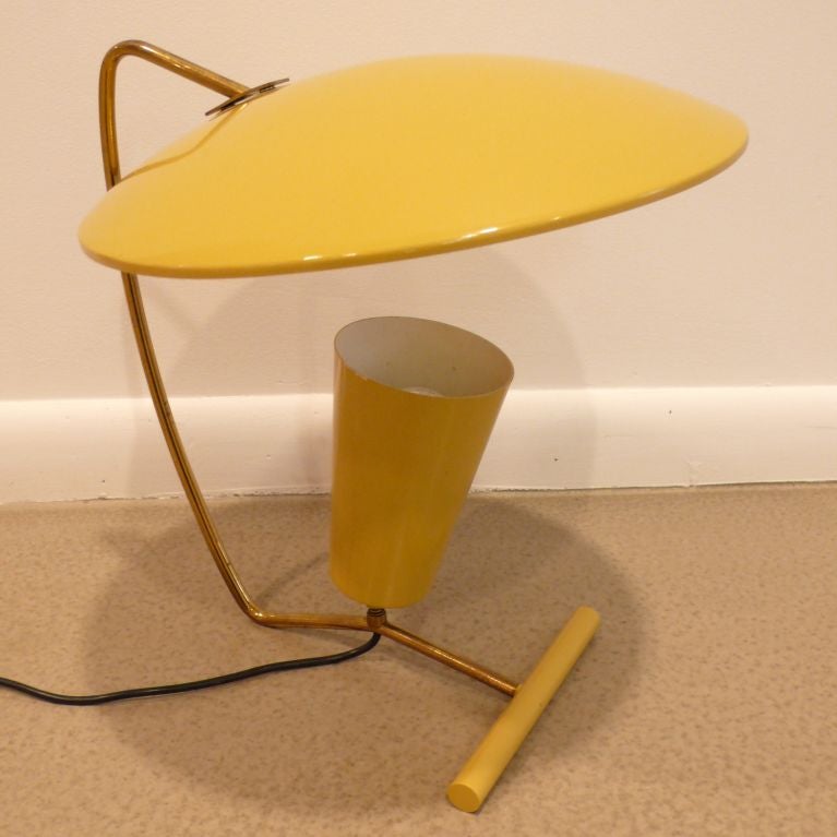 Reflector lamp in enamelled metal and brass, with adjustable light source, produced by Stilnovo, Italy, in the 1950's. Rare and sculptural form, with original mustard yellow enamel paint. Labelled.  The saucer reflector measures 14