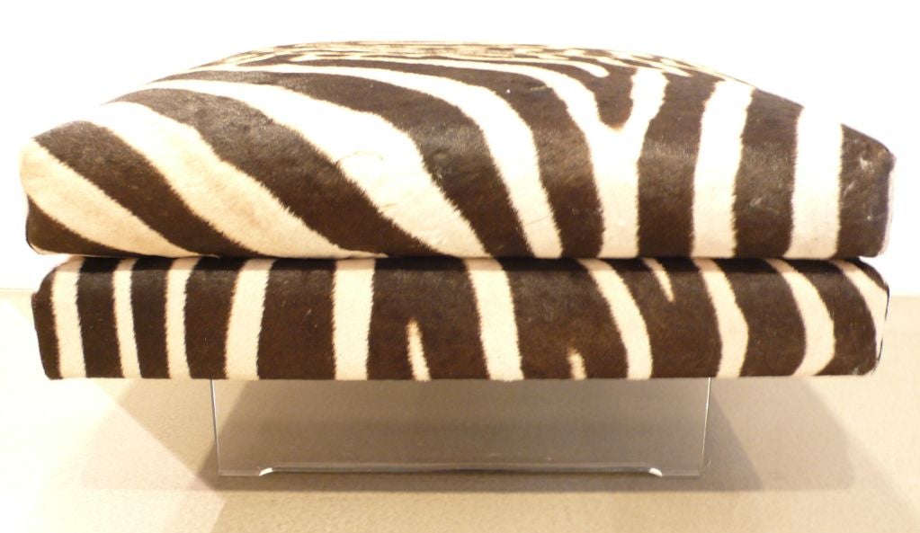 Ottoman with lucite base by Vladimir Kagan, produced c. 1968. Newly upholstered in zebra hide. Very chic, as long as you're not a zebra.  A standout and stand alone decorative piece.