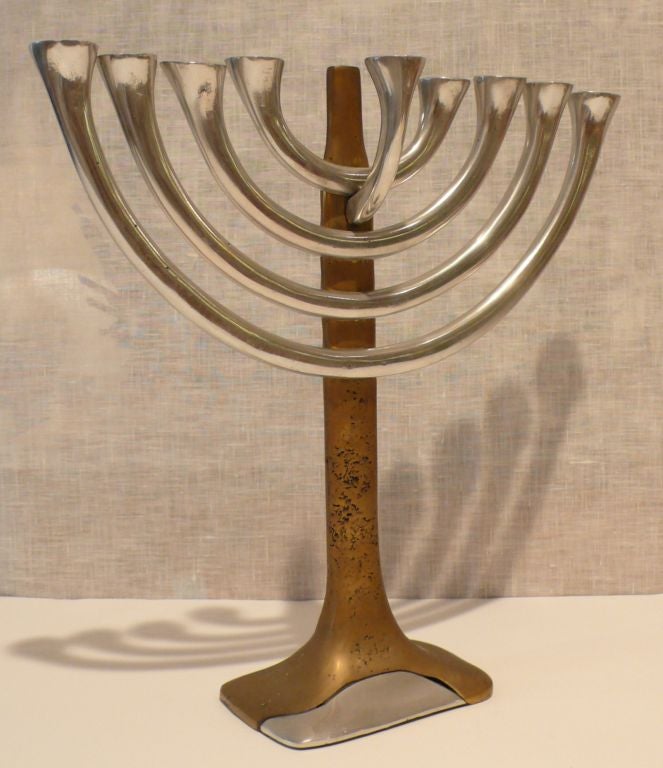 Interesting and unusual menorah of cast aluminum and brass, with both craft and frankly industrial elements.  Paper remnant on base, in Spanish, indicates possible Latin American origin.  Note the brass screws as design element on the back.