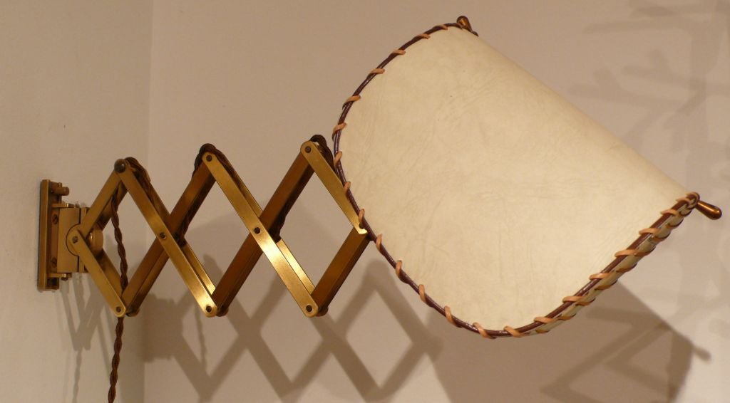 Adjustable brass accordian sconces with adjustable parchment shades.  The sconces telescope from about 8