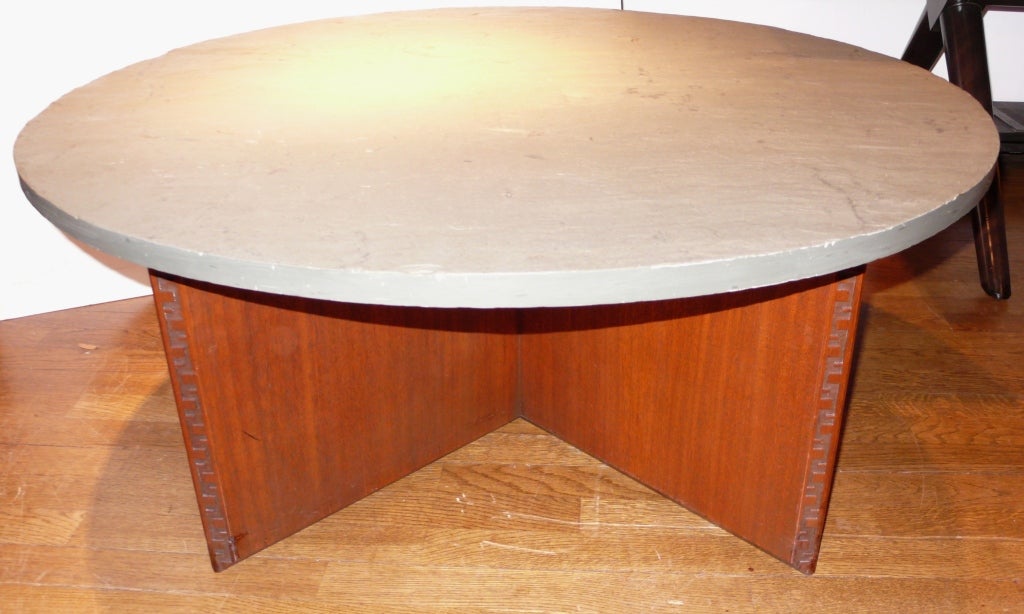 Mahogany cocktail table with cruciform base and the rare round slate top.  Edges feature  Wright's Taliesen motif.  Marked with Wright's insignia and stencil dated to 1955.