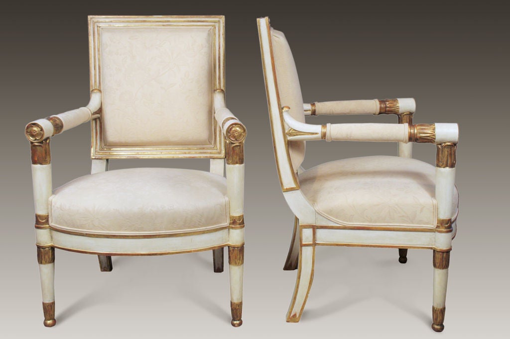 The painted and parcel gilt upholstered back flanked by upholstered round arms ending in gilt florets.  The bowed attached seat raised on white and parcel gilt legs ending in ball feet.