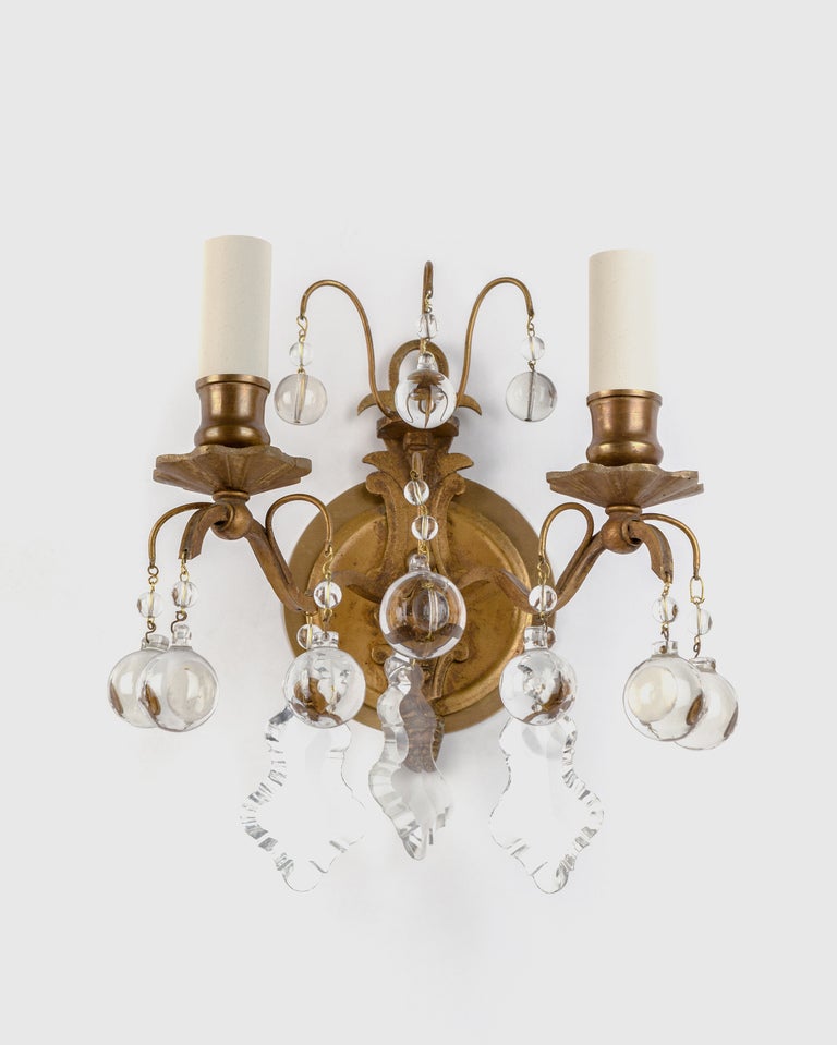A pair of double light gilded bronze and crystal sconces
