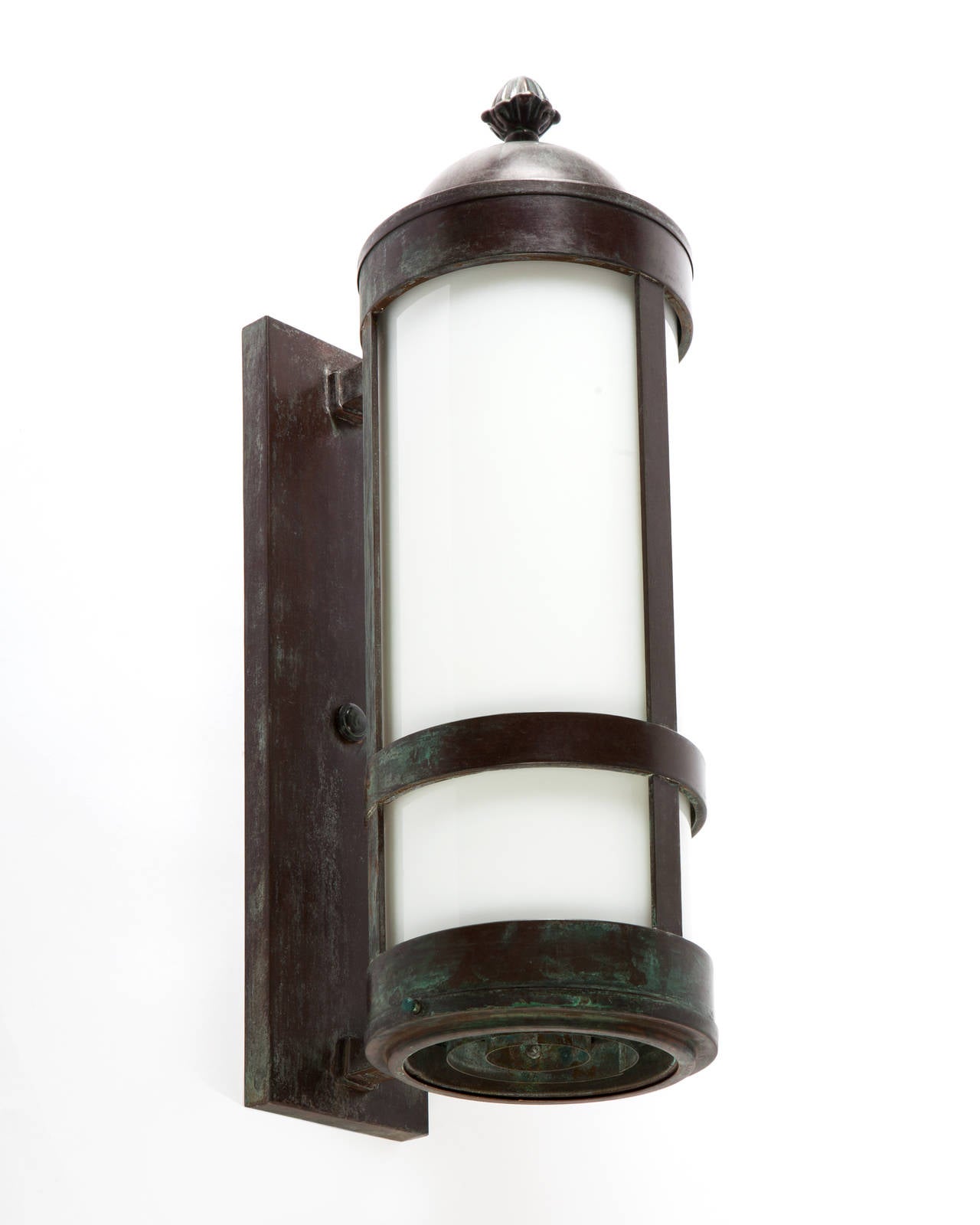 AEX0574
A pair of cylindrical wall lanterns with strapwork details in their original aged copper finish. Having white glass lenses.

Overall: 21-3/4