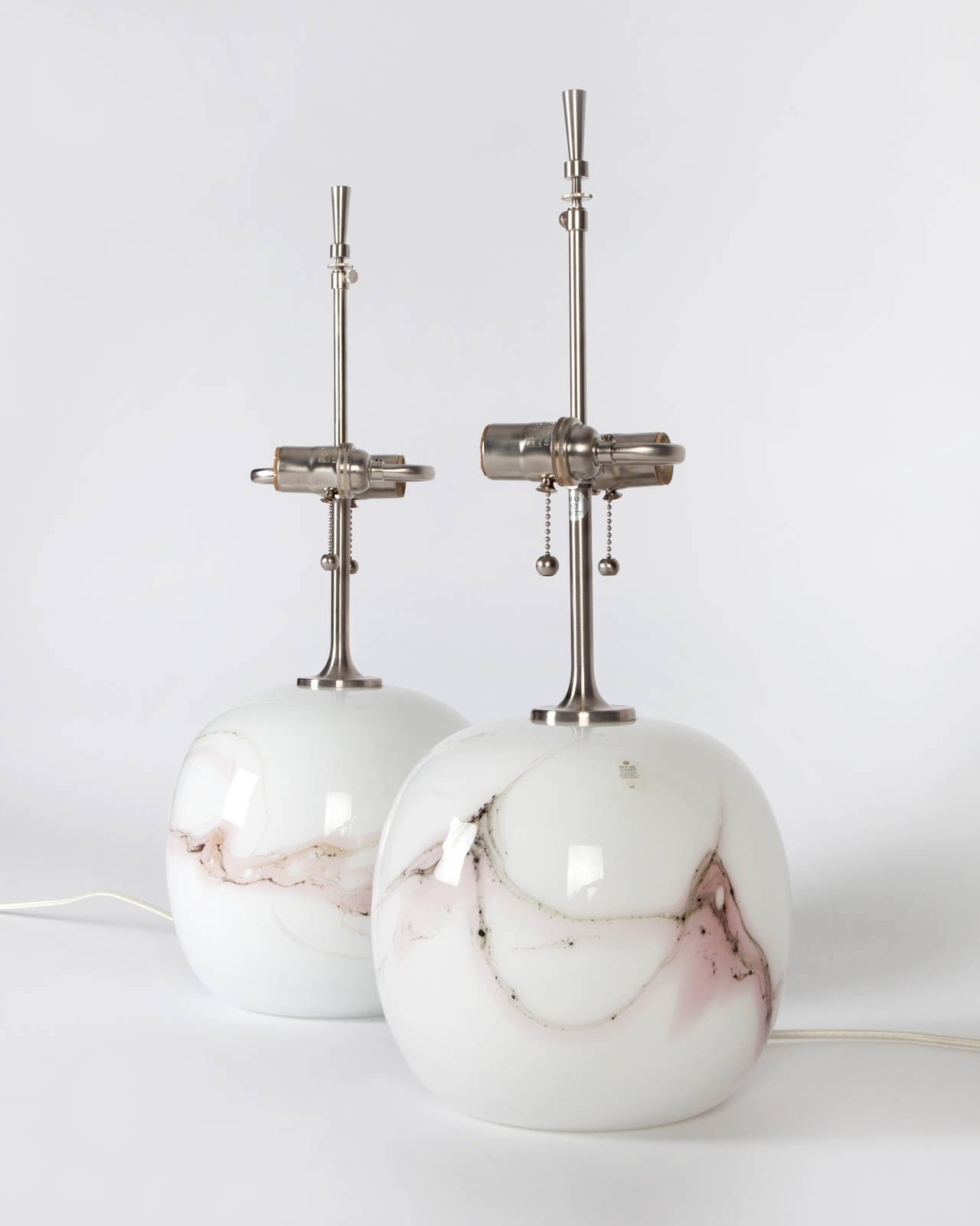 ATL1902

Circa 1980
A pair of “Sakura” glass lamps with satin nickel fittings. Signed by Michael Bang for the Danish maker Holmegaard. Due to the antique nature of this fixture, there may be some nicks or imperfections in the