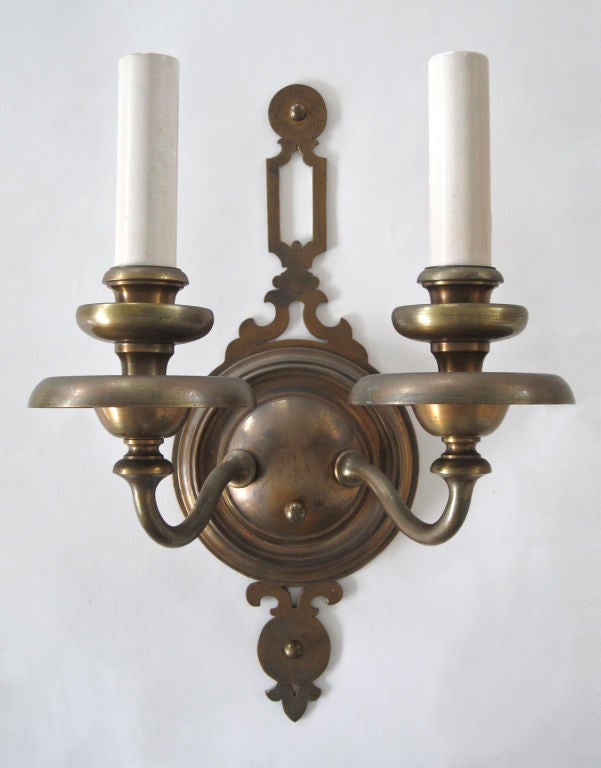 AIS2627

A pair of double light bronze sconces having circular backplates with pierced tops and broad waxpans supported by flared arms. Shown in their original antique finish. By the Meriden, CT. maker Bradley and Hubbard.

Backplate: 16 7/8