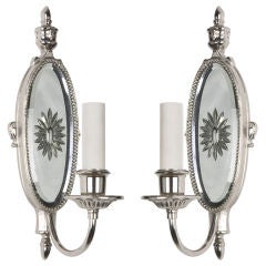 A pair of antique silver single-light mirrorback sconces