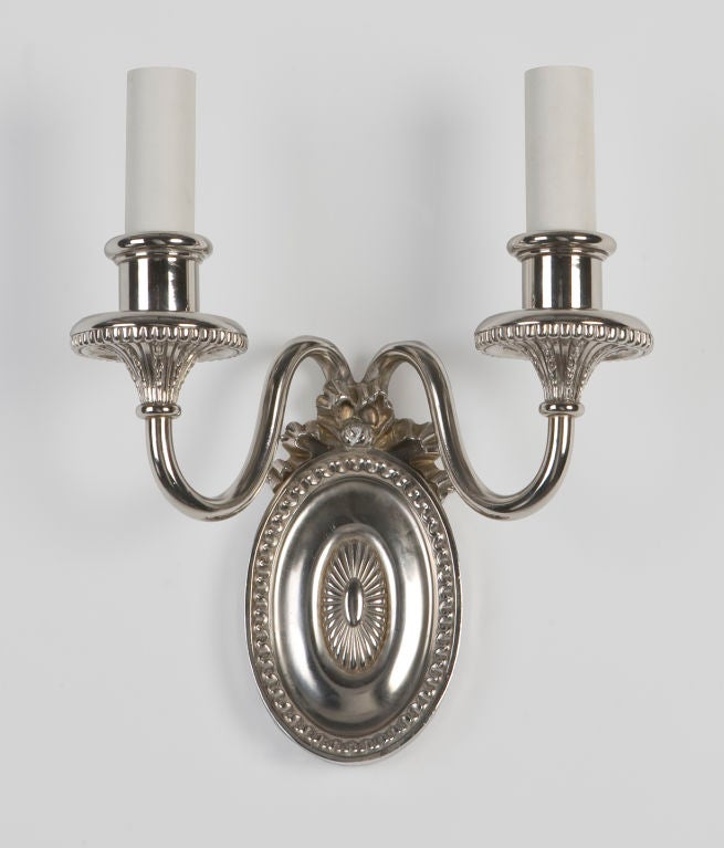 AIS2709

A pair of double-light sconces with bellflower details in the bobeches and a bow-topped leaf and dart bordered oval backplate. In an aged nickel finish signed by the New York maker E. F. Caldwell.

Backplate: 5-7/8