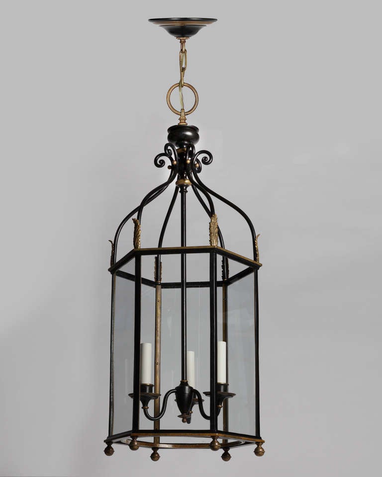 Circa 1910.  An antique three-light bronze hexagonal lantern having very slender framing with fine cast leaf and beaded details in black lacquer and bright bronze.

DIMENSIONS
Current height: 76-1/4