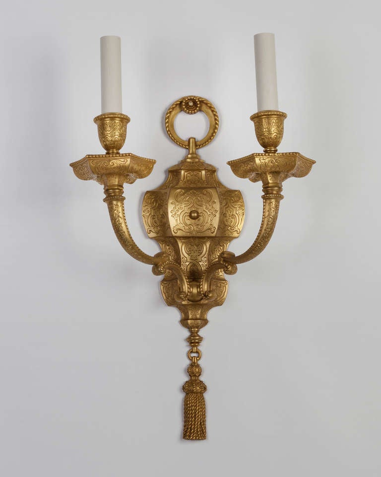 Circa 1920.  A pair of double light sconces with finely engraved surface details in their original gilded finish. Signed by the New York maker E. F. Caldwell.

DIMENSIONS
Overall: 20