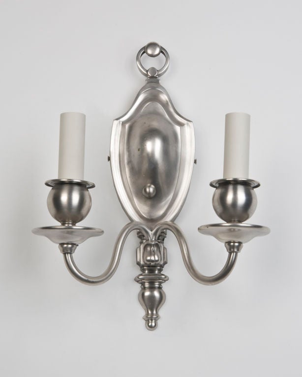 AIS2736
A pair of double light sconces in silverplate over brass having shield form backplates. Signed by the maker Bradley and Hubbard. Circa 1910s.

Dimensions:
Overall: 13-1/4