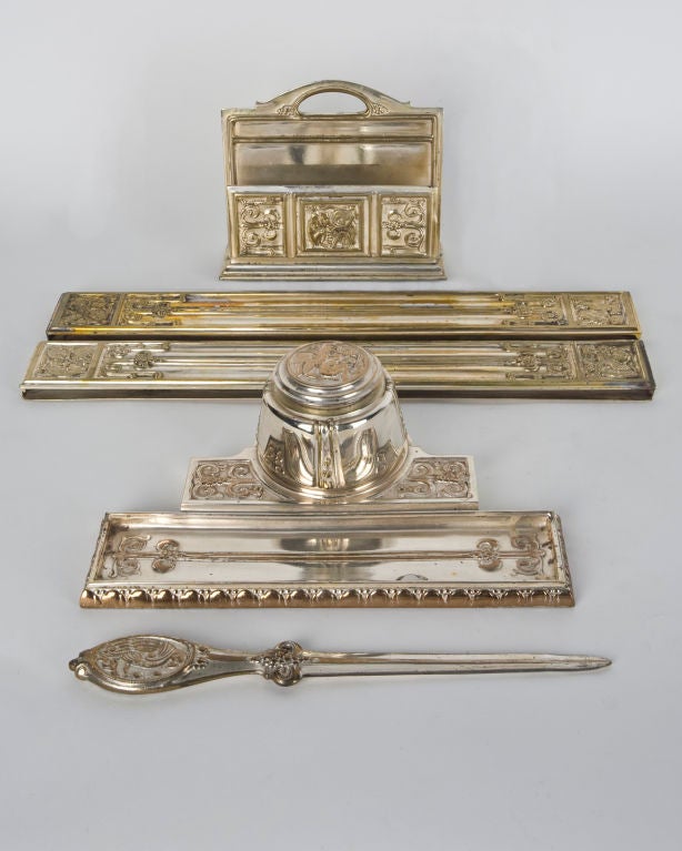 ATA1393<br />
A silverplate desk set including one inkwell, one envelope holder, one letter opener and two blotter edges. Signed by the New York maker Sterling Bronze Co.<br />
<br />
Overall: 8