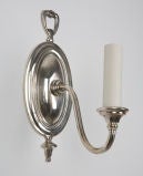 A pair of single arm silvered sconces