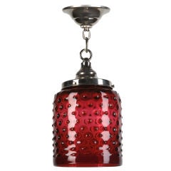 A red hand-blown hobnail-patterned glass pendant