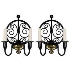 A pair of two-arm iron and brass sconces